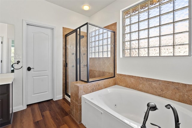 full bathroom featuring a healthy amount of sunlight, wood finished floors, a shower stall, and a whirlpool tub