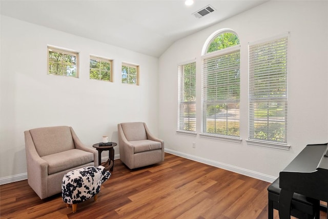 sitting room featuring lofted ceiling, wood finished floors, visible vents, and baseboards