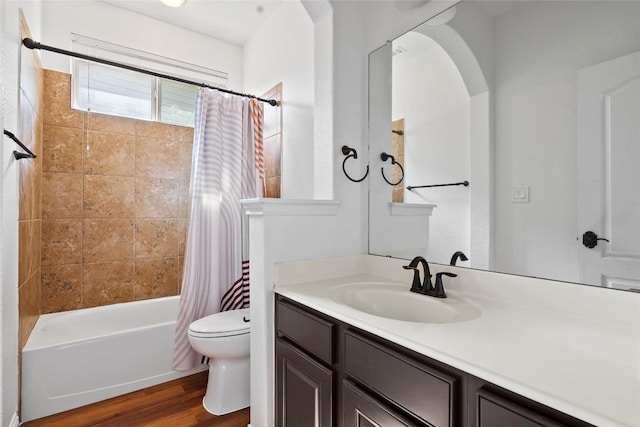 full bathroom with shower / bath combo with shower curtain, wood finished floors, toilet, and vanity