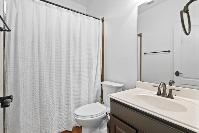 bathroom featuring visible vents, toilet, a shower with curtain, and vanity