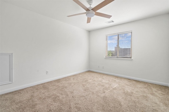 unfurnished room with a ceiling fan, visible vents, light carpet, and baseboards
