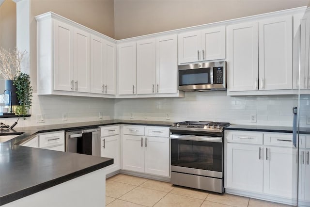 109 Perpetuation Dr, Austin, TX 78734 - kitchen featuring appliances with stainless steel finishes, dark countertops, white cabinetry, and backsplash