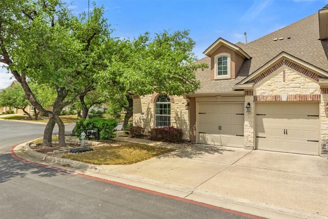 109 Perpetuation Dr, Austin, TX 78734 - view of front of property with stone siding, roof with shingles, concrete driveway, and an attached garage