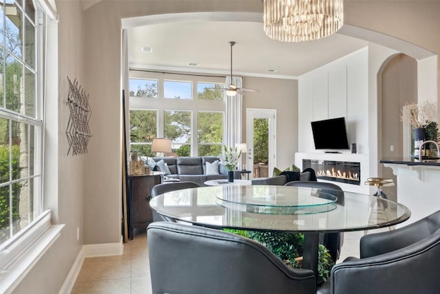 109 Perpetuation Dr, Austin, TX 78734 - dining area with baseboards, light tile patterned flooring, a glass covered fireplace, a chandelier, and arched walkways