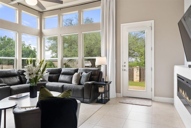 109 Perpetuation Dr, Austin, TX 78734 - living room featuring a ceiling fan, light tile patterned floors, a lit fireplace, and baseboards