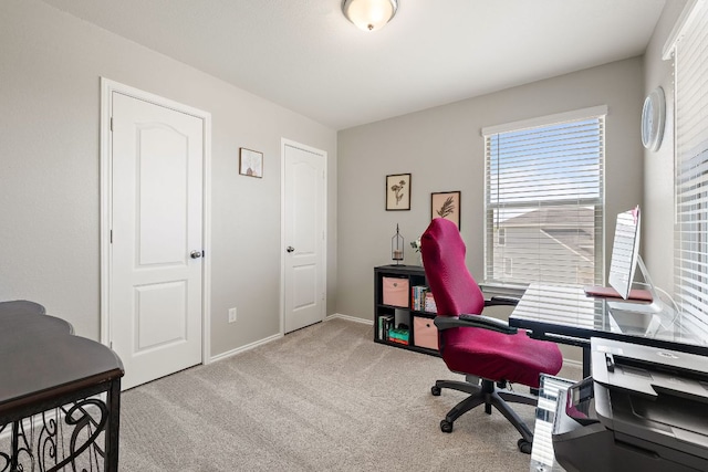 carpeted home office featuring baseboards