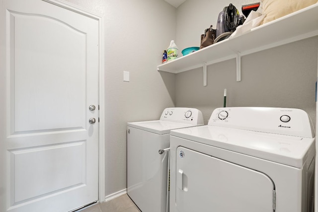 laundry room featuring washing machine and dryer, light tile patterned floors, and laundry area