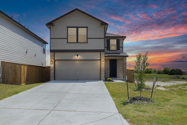 traditional home with fence, concrete driveway, a front yard, and a garage