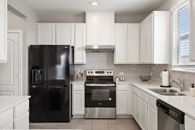 kitchen featuring tasteful backsplash, a sink, appliances with stainless steel finishes, light countertops, and under cabinet range hood