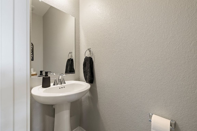 bathroom featuring a textured wall