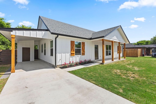 modern farmhouse with fence, a shingled roof, concrete driveway, board and batten siding, and a front yard