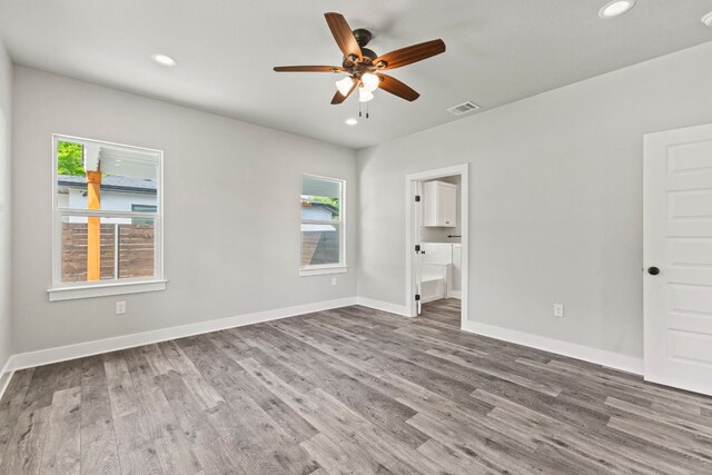 unfurnished bedroom with recessed lighting, wood finished floors, visible vents, and multiple windows