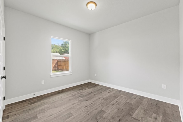 empty room featuring baseboards and wood finished floors