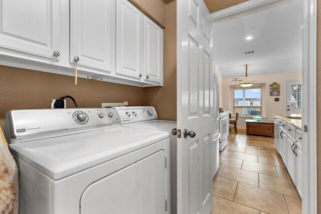 3325 Cantera Way, Round Rock, TX 78681 - laundry room featuring cabinet space, washing machine and clothes dryer, and light tile patterned flooring
