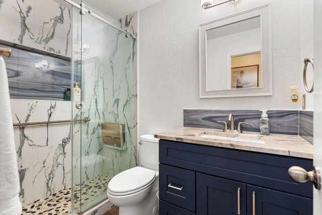 3325 Cantera Way, Round Rock, TX 78681 - bathroom with vanity, toilet, a marble finish shower, and a textured wall