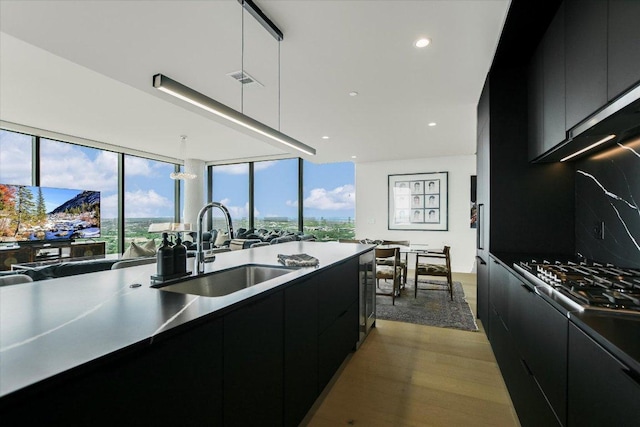 44 E Ave Unit 3906, Austin, TX 78701 - kitchen featuring dark cabinetry, modern cabinets, wood finished floors, beverage cooler, and recessed lighting