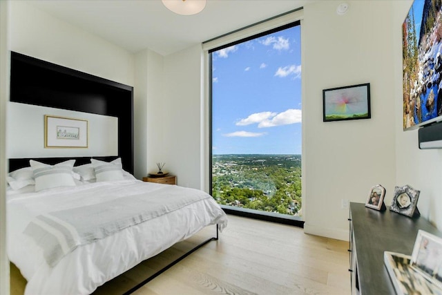 44 E Ave Unit 3906, Austin, TX 78701 - bedroom featuring a wall of windows and light wood-style floors