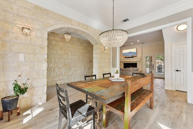 203 Saddle Blanket Dr, Dripping Springs, TX 78620 - dining area featuring crown molding, light wood-style floors, a chandelier, and arched walkways