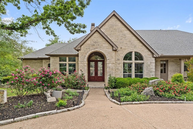 4616 High Gate Dr, Austin, TX 78730 - view of front of property featuring stone siding, a chimney, french doors, and a shingled roof