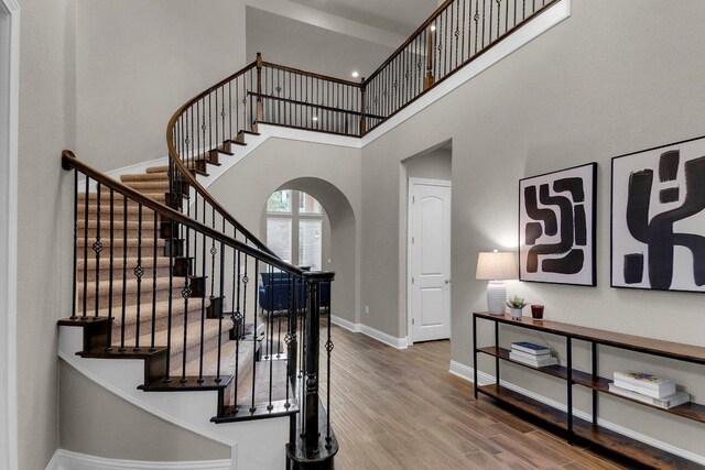 2601 Montebelluna Pl, Leander, TX 78641 - stairs with arched walkways, a towering ceiling, and wood finished floors