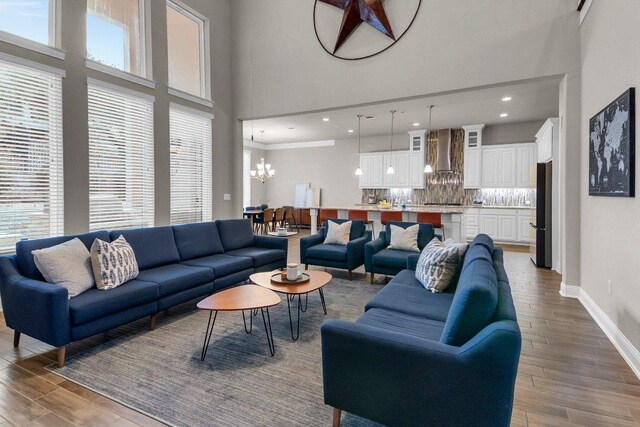 2601 Montebelluna Pl, Leander, TX 78641 - living room with a chandelier, a high ceiling, wood finished floors, and recessed lighting