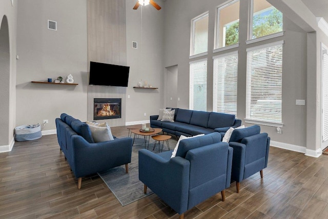 2601 Montebelluna Pl, Leander, TX 78641 - living room with a high ceiling, wood finished floors, ceiling fan, a glass covered fireplace, and healthy amount of natural light
