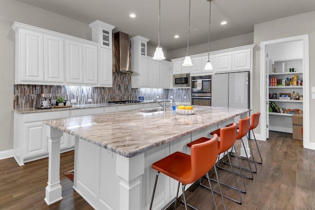 2601 Montebelluna Pl, Leander, TX 78641 - kitchen featuring wall chimney range hood, appliances with stainless steel finishes, white cabinetry, backsplash, and recessed lighting