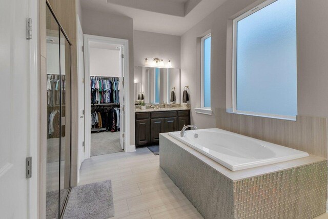 2601 Montebelluna Pl, Leander, TX 78641 - bathroom with a garden tub, vanity, a walk in closet, and a stall shower