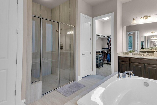 2601 Montebelluna Pl, Leander, TX 78641 - full bath featuring vanity, a shower stall, a walk in closet, and a garden tub