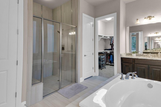 2601 Montebelluna Pl, Leander, TX 78641 - full bath featuring vanity, a shower stall, a walk in closet, and a garden tub