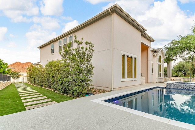 2601 Montebelluna Pl, Leander, TX 78641 - back of property with a patio area, stucco siding, and a pool with connected hot tub