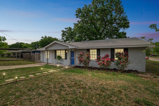 ranch-style house featuring fence, brick siding, and a front yard