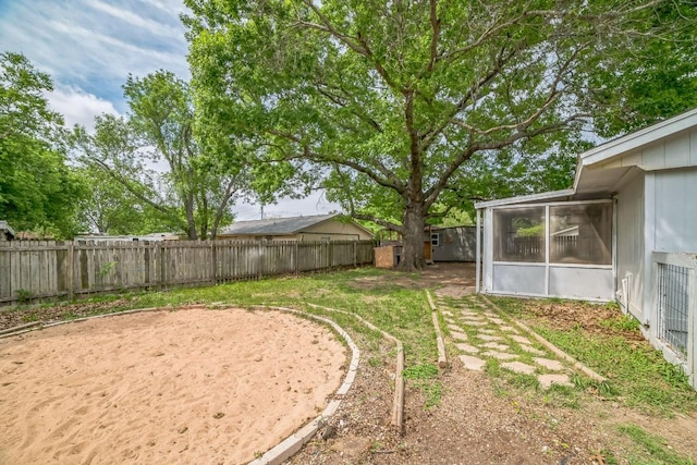 view of yard featuring a fenced backyard and a sunroom