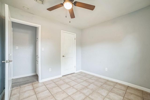 unfurnished bedroom featuring ceiling fan, baseboards, light tile patterned flooring, and visible vents