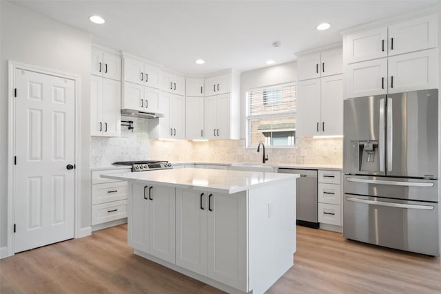 1006 Mesquite Hollow Pl, Round Rock, TX 78665 - kitchen with stainless steel appliances, under cabinet range hood, light countertops, light wood finished floors, and recessed lighting
