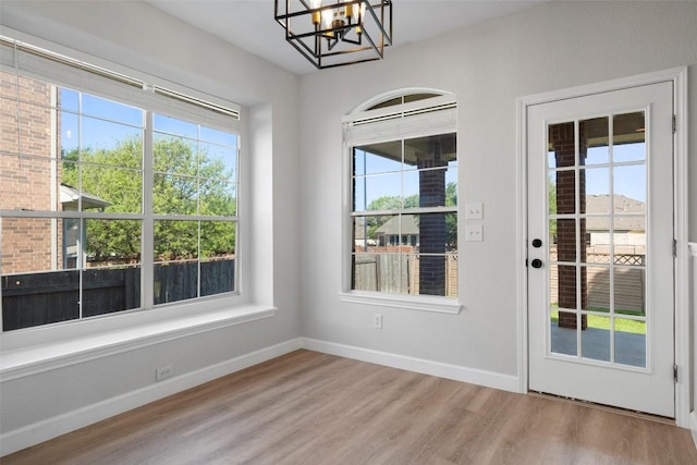 1006 Mesquite Hollow Pl, Round Rock, TX 78665 - doorway with a chandelier, light wood-style flooring, healthy amount of natural light, and baseboards