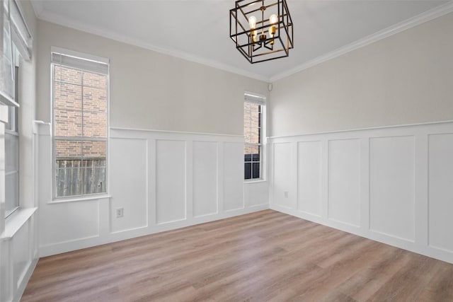 1006 Mesquite Hollow Pl, Round Rock, TX 78665 - unfurnished dining area with a decorative wall, a chandelier, crown molding, light wood-style floors, and wainscoting