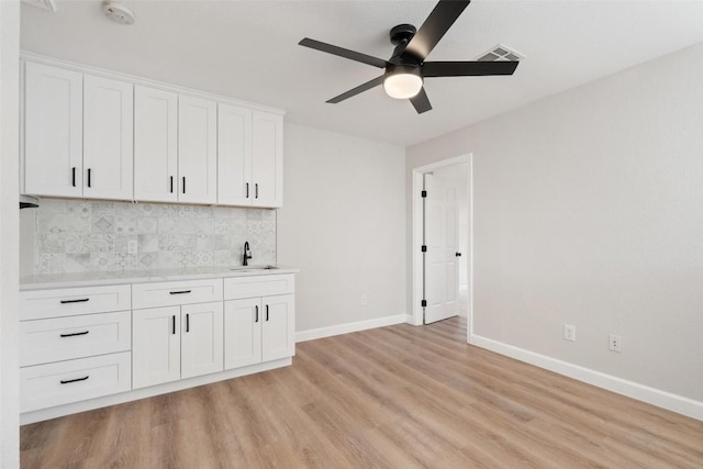 1006 Mesquite Hollow Pl, Round Rock, TX 78665 - kitchen with a sink, light wood-style floors, a ceiling fan, baseboards, and light countertops