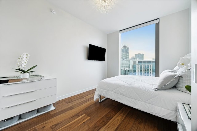 bedroom with expansive windows, baseboards, and dark wood-type flooring