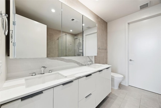 bathroom with visible vents, a sink, a shower stall, and double vanity