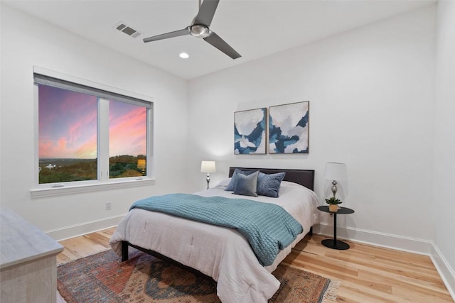 bedroom with baseboards, wood finished floors, visible vents, and recessed lighting