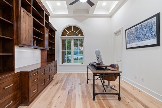 office area with a ceiling fan, light wood finished floors, coffered ceiling, ornamental molding, and beam ceiling