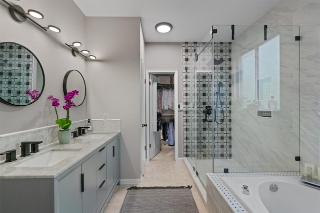 full bath featuring double vanity, tile patterned floors, a stall shower, and a sink