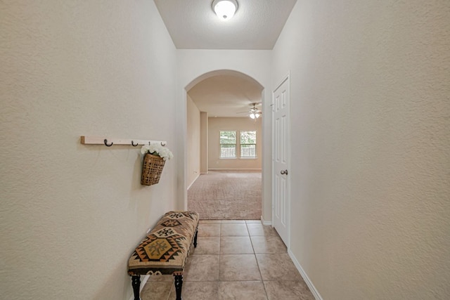 850 Hobby Rd, Copperas Cove, TX 76522 - hall with arched walkways, light tile patterned floors, light carpet, baseboards, and a textured wall