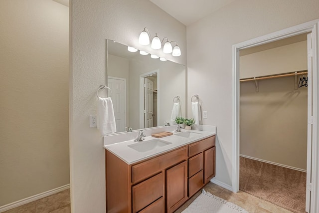 850 Hobby Rd, Copperas Cove, TX 76522 - bathroom with double vanity, a walk in closet, tile patterned flooring, and baseboards