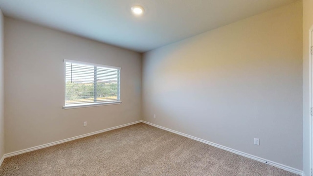 spare room featuring carpet floors and baseboards
