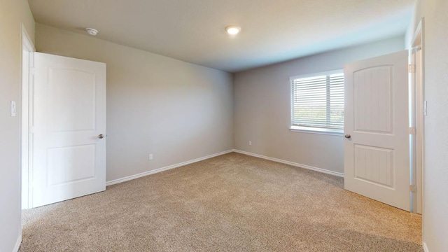 carpeted spare room with baseboards