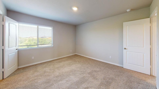 empty room with light carpet and baseboards