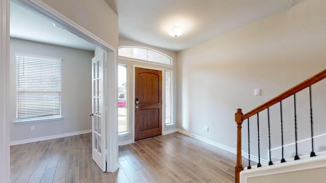 entrance foyer with stairway, baseboards, and wood finished floors