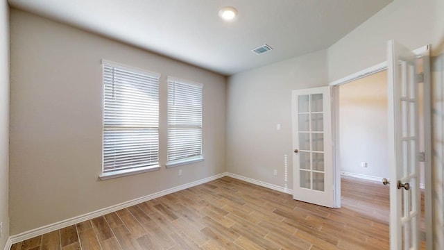 spare room with light wood-style flooring, visible vents, baseboards, and french doors